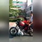 La niña conduce la motocicleta de su padre en una carretera en China
